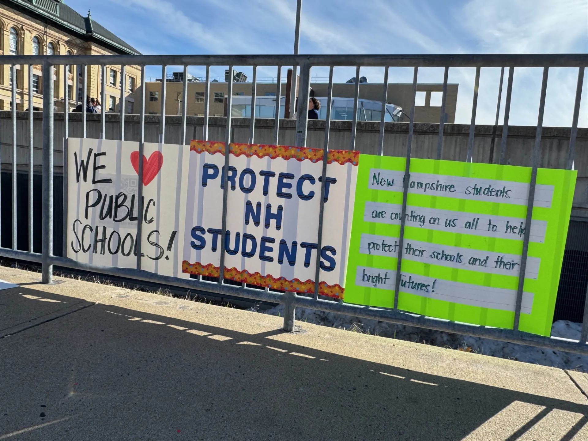 A sign reads "Protect NH Students"