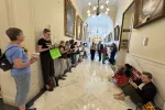 A group of advocates reads in the hallway outside of Governor Ayotte's office to protest a book ban bill.