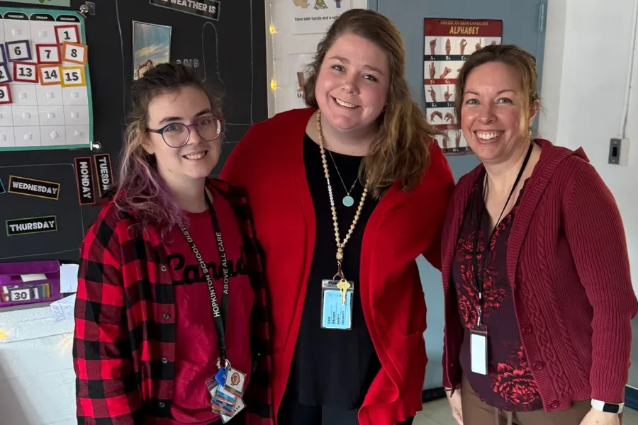 members in red on March 19 in a classroom with a wall calendar set to March