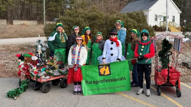A group of paraprofessionals dressed for the holidays with a float