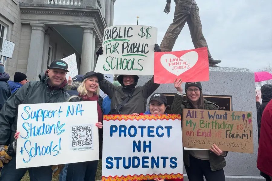 members at rally with signs thaty say "Support NH Students and Schools" and "Protect NH Students"