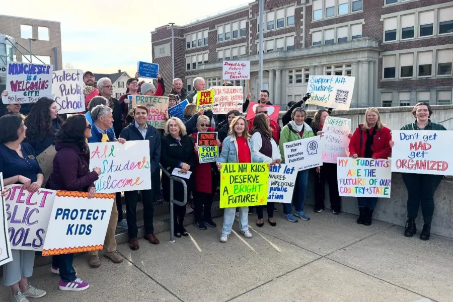 Members at walk-in with signs - one sign reads, _all NH kids deserve a bright future