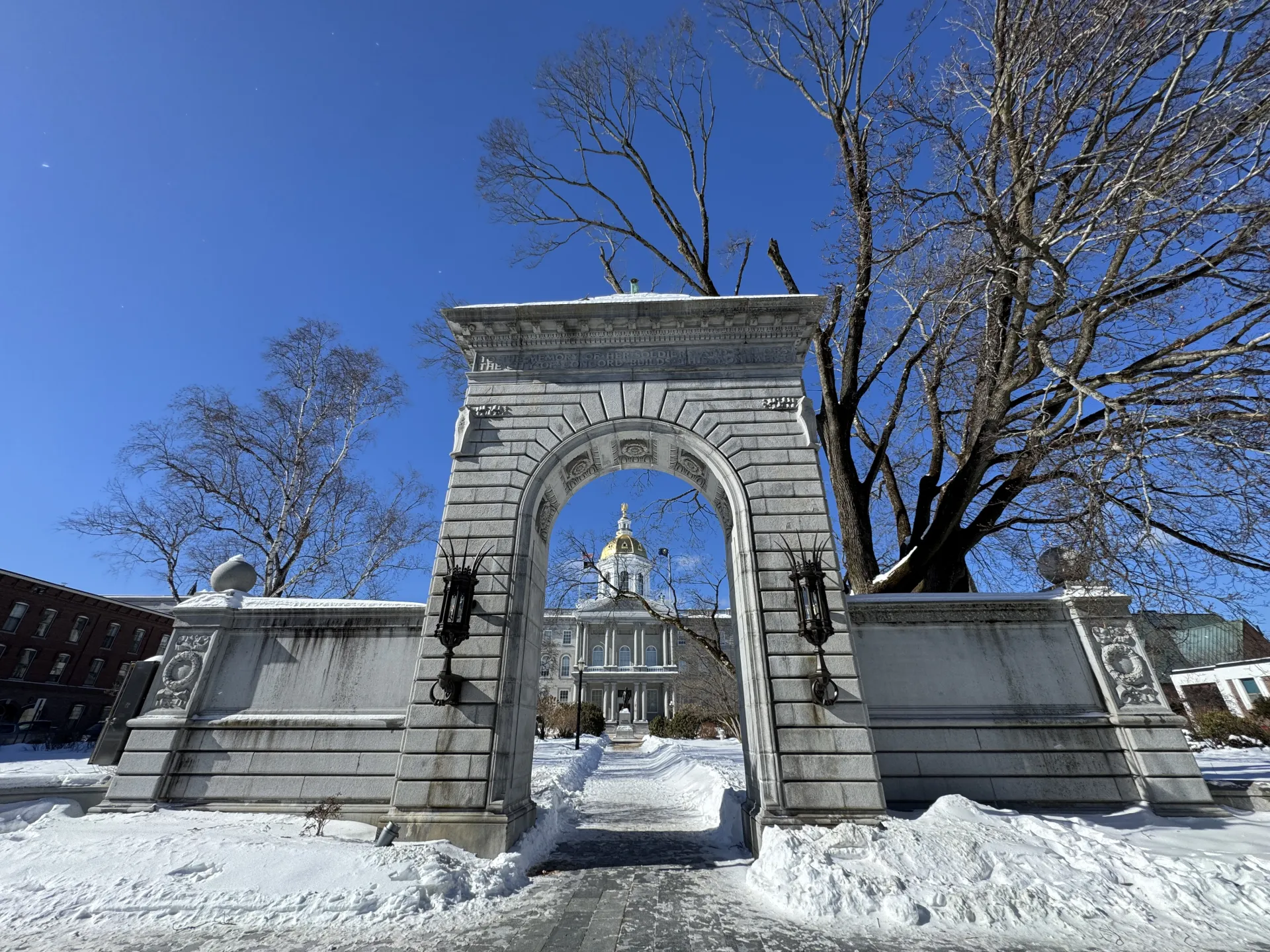 An image of the New Hampshire State House complex arch in winter.