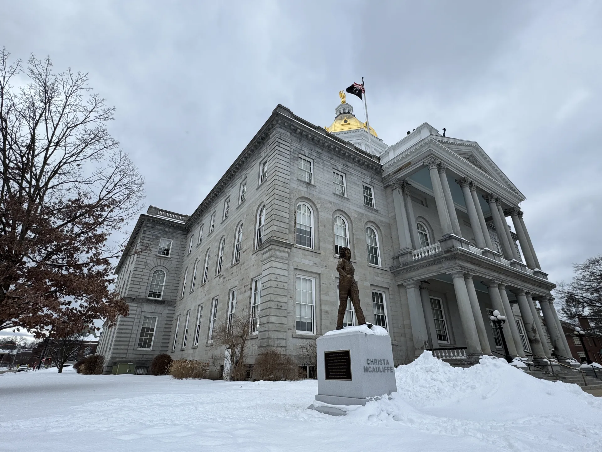 An image of the New Hampshire State House and Christa McAuliffe statue in winter.